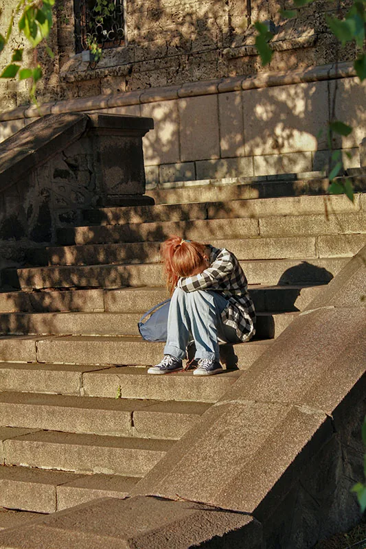 Student sitting alone on outdoor steps